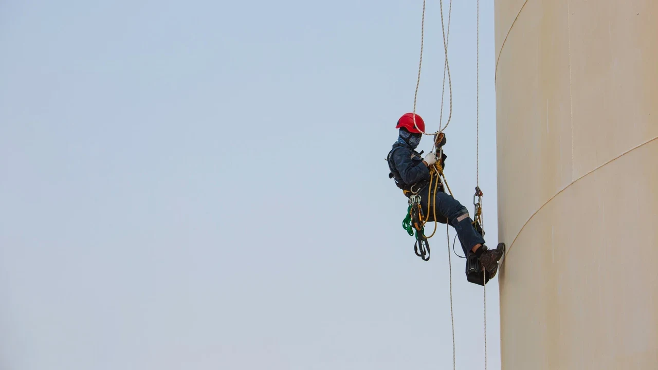 Trabalhador suspenso por corda em altura em silo industrial durante resgate NR-35 em Sorocaba
